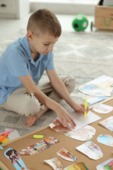 Creating vision board. Little boy drawing on paper indoors