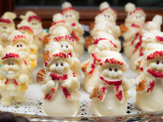Delightful edible Christmas figurines made of white and red candy, featuring black eyes. These handmade sweets from Florence, Italy, add a sweet touch to your holiday decorations and treats.