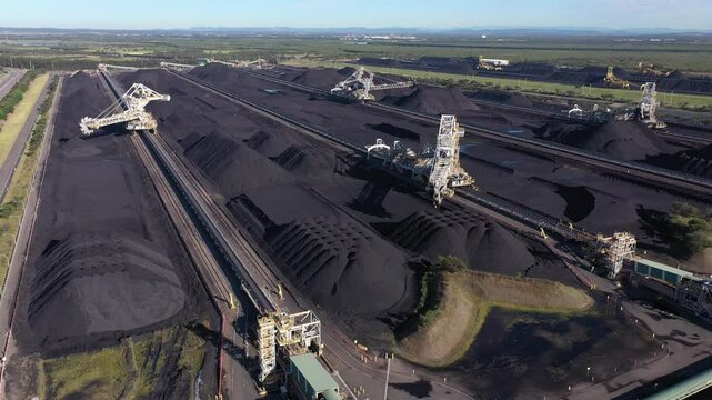 Aerial view of piles of bituminous coal and coal conveyors used for loading coal onto bulk carriers for export, Newcastle, NSW, Australia