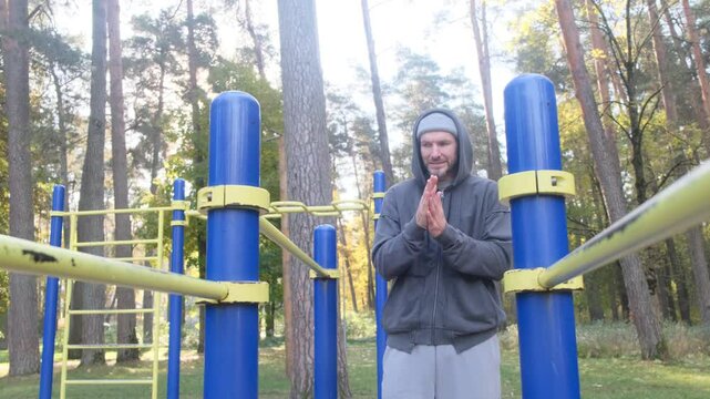 Man working out on parallel bars in a park. Fitness, outdoors, healthy lifestyle, strength, exercise concept