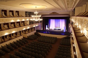 Theatre interior with stage, rows of comfortable seats and beautiful chandelier