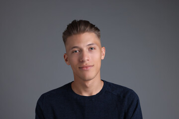 Fototapeta premium Handsome young man with stylish haircut on grey background