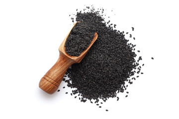 A wooden scoop filled with organic Black Sesame (Sesamum indicum) Seeds powder, placed beside a heap of black sesame seeds, isolated on a white background.