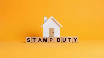 Stamp Duty Concept with House Model on Wooden Blocks Against Orange