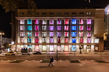 A building with colorful windows is lit up at night