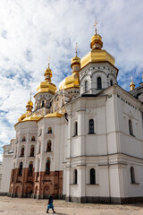A large white building with gold domes and a gold cross on top