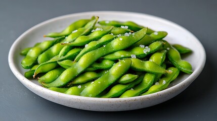 Steamed edamame beans with sea salt on a plate.