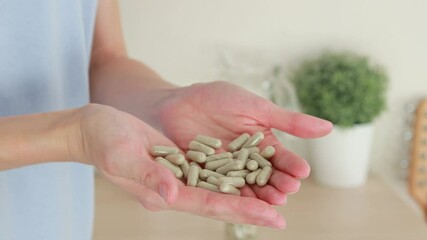 Close-up of a woman holding a handful of gray pill capsules in her palms. Medicines and dietary supplements