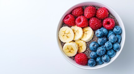Chia seed pudding with raspberries, blueberries, and banana slices in a white bowl.