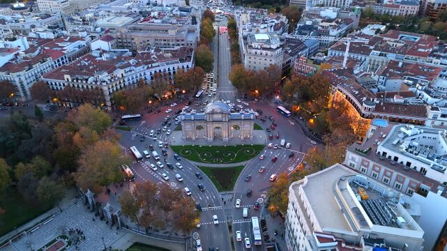 Breathtaking aerial footage of Madrid highlights the bustling traffic, iconic Puerta de Alcala, and the lush greenery of El Retiro Park, framed by the citys historic architecture and cultural heritage