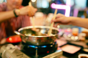 Blur background of people having a hot pot. Sukiyaki hot pot boiled