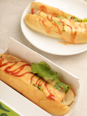 Hotdog with mayonnaise and ketchup drizzled on white background