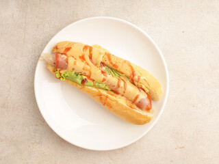 Hotdog with mayonnaise and ketchup drizzled on white background