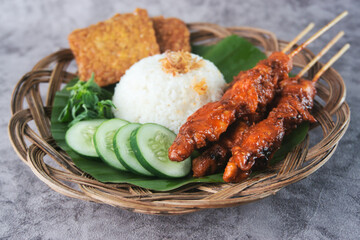 Traditional Indonesian Meal with Satay, Rice, Tempeh, and Fresh Vegetables