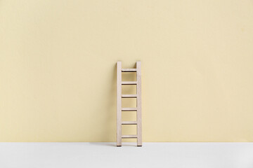Wooden ladder on beige background