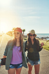 Friends, beach walk and happy with skateboard on summer holiday for adventure together. Women, fun...