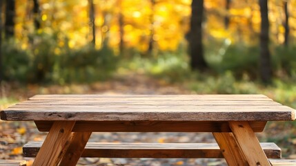 Fototapeta premium Rustic wooden picnic table in serene autumn forest with vibrant yellow leaves