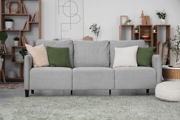 Interior of modern living room with grey sofa, pouf and coffee table