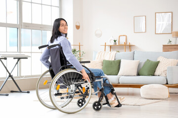 Beautiful young woman in wheelchair at home