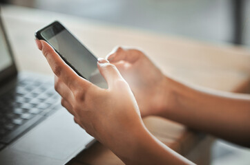 Hands, blank phone screen and texting in home with laptop, click and contact with mock up space. Person, smartphone and remote work with mobile app, communication and scroll on web at apartment