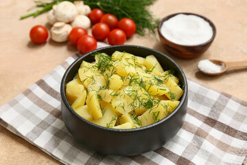 Bowl of tasty potato salad with dill, mushrooms, tomatoes and salt on beige grunge background