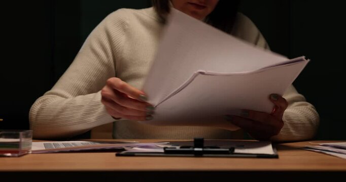 Organizing important documents on a table at night in office