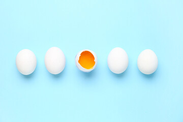 Raw chicken eggs on blue background