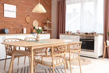 Interior of modern kitchen with counters, dining table and window