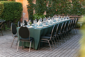 outdoor long table served by tableware cutlery in outdoor vintage yard garden aesthetic environment without people