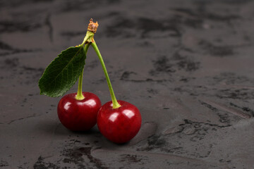 Fresh red cherries with green leaves isolated on black background.  Natural background.
