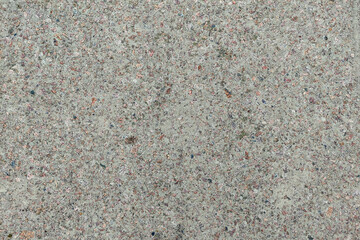 Concrete texture. Pebbles of different colors and signs of aging are visible.