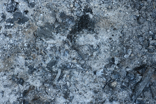 Black ash charcoal from oven background texture, gray wood ash coal in fireplace. Pile of ash charcoal after fire.