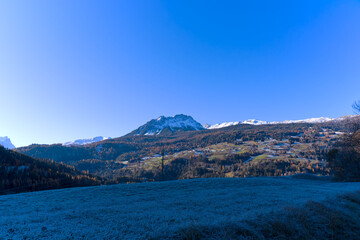 Naklejka premium Mountain panorama with idyllic Swiss mountain village of Mon with church and traditional houses in the background on a sunny autumn day. Photo taken November 15th, 2024, Mon, Switzerland.
