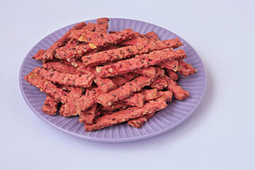 Delicious homemade cookies with seeds and vegetables on a purple plate, on a light background