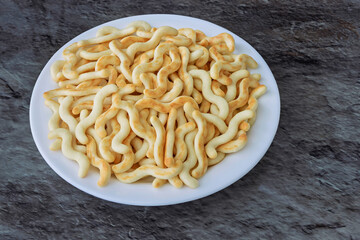 Crunchy organic mini crackers served on a white plate on the table