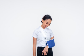 Young woman wearing an arm sling isolated against a white background