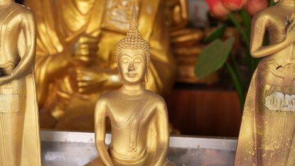Golden Buddha Statue Surrounded by Decorative Religious Figures