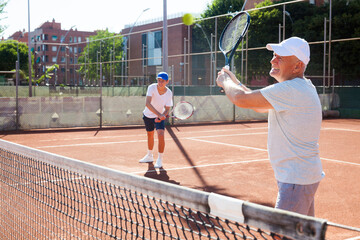 Grandfather and grandson playing tennis court
