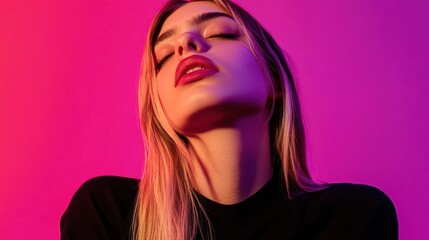Fototapeta premium Close-up portrait of a young woman with eyes closed, illuminated by vibrant pink and purple lighting.