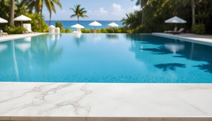 Fototapeta premium A clear view of a swimming pool with a clear blue water surface in the background. The foreground features a marble countertop. In the distance, there are white umbrellas and palm trees , suggesting a