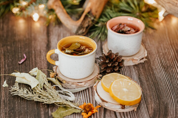 Cozy winter vibes with herbal tea, dried citrus slices, and seasonal decor – Christmas lights and fir tree branches