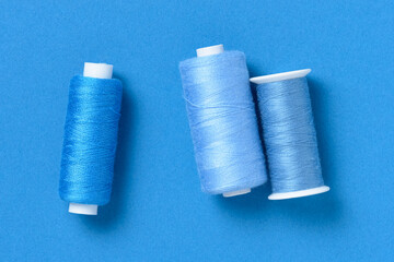 Blue thread spools background with copy space for text close-up flat lay top view