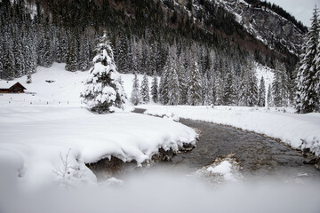 winter wonderland in Salzburg, a river goes through the landscape covered in snow