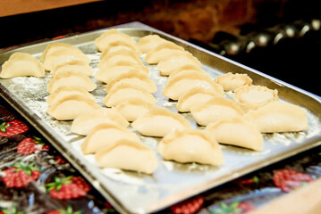 Chef in restaurant kitchen prepare dumplings, dish of dough meat cooked saucepan