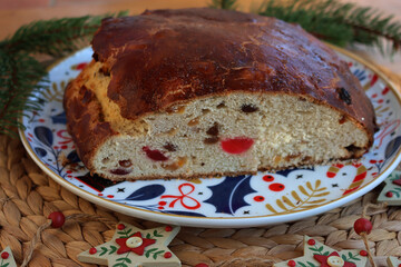 Christollen. Tradiotional sliced bread with candied fruits made for Christmas on a plate on wooden table