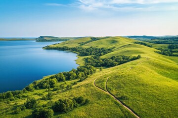 Aerial View of Lush Green Hills Overlooking Serene Lake and Open Sky on a Clear Day, Perfect for Nature Lovers and Outdoor Enthusiasts Seeking Tranquility