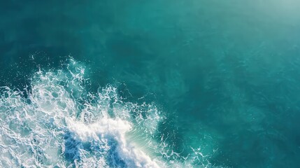 Naklejka premium A breathtaking view of a crystal-clear teal blue ocean wave cresting and breaking under the sunlight,