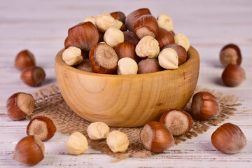 Hazelnuts, shelled and in shell, in a wooden bowl.	