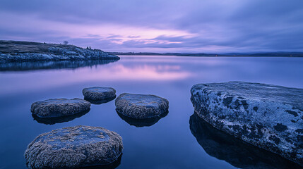 A calm lakeside view, where smooth granite stones covered in soft lichen gently meet the water, the sky painted in soft purples and blues as evening settles in. 