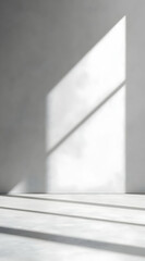 Obraz premium A minimalist interior with light casting geometric shadows on a concrete wall.